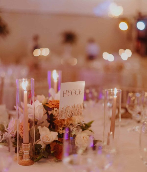 Una mesa de boda con flores, velas y un cartel que dice "HYGGE.
