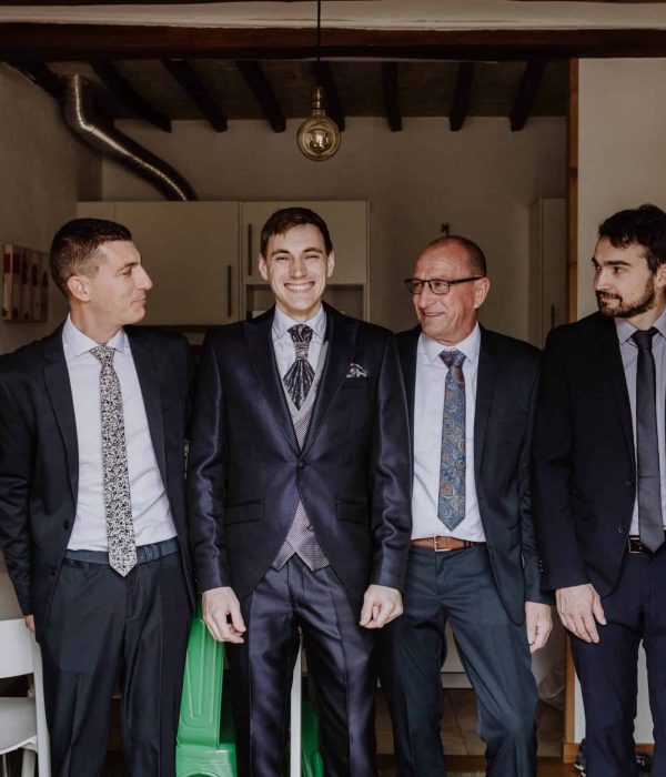 Seis hombres vestidos de traje están juntos en una habitación, sonriendo.